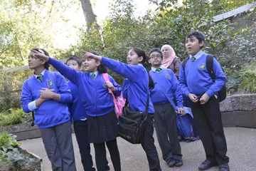 Students point excitedly to the left at London Zoo