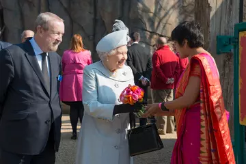 A ZSL conservationist presents HM The Queen with a bouquet of flowers