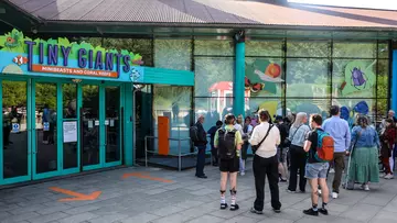 A group of people waiting outside Tiny Giants at London Zoo