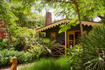 Peacock lodge in the sun with two guests on veranda 