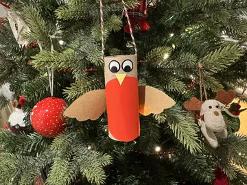 A recycled robin Christmas tree decoration hanging on a tree