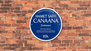 A circular blue plaque on a wall 