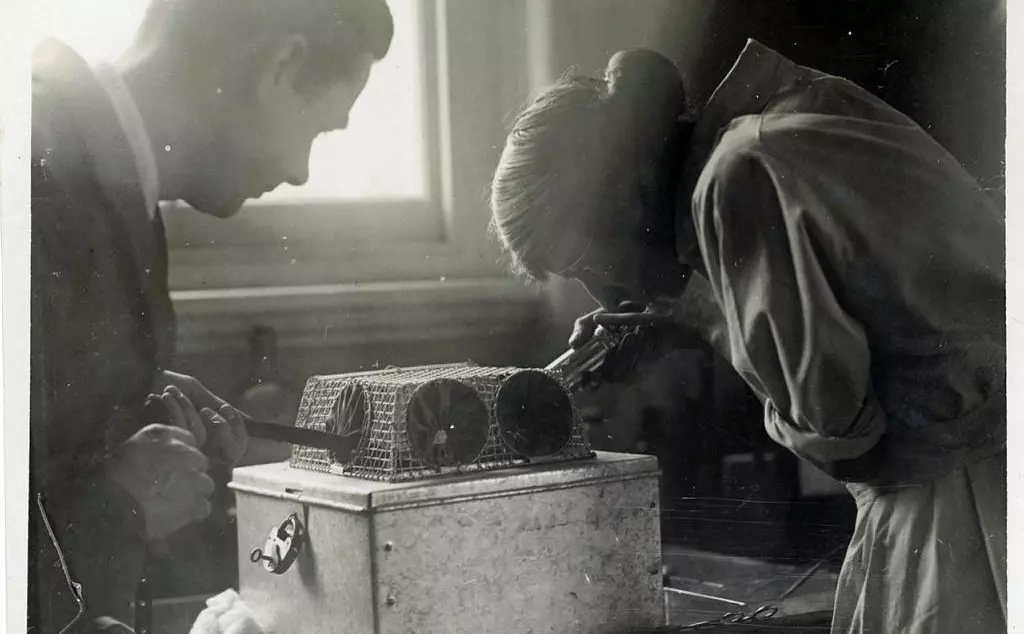 Joan Proctor and a zookeeper with her rodent device for holding snakes.