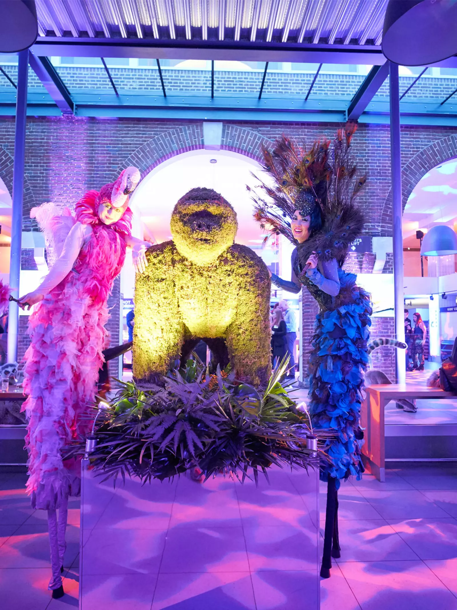 People at an event in The Terrace Restaurant which is decorated with pink lighting and a giant golden gorilla and 