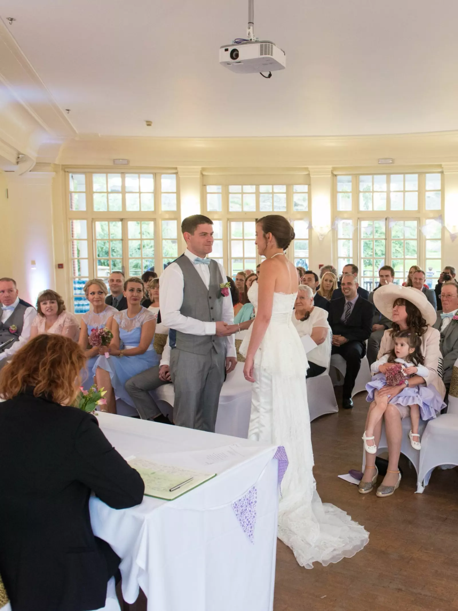 Wedding couple at the altar in the Mappin Pavilion watched by seated guests 