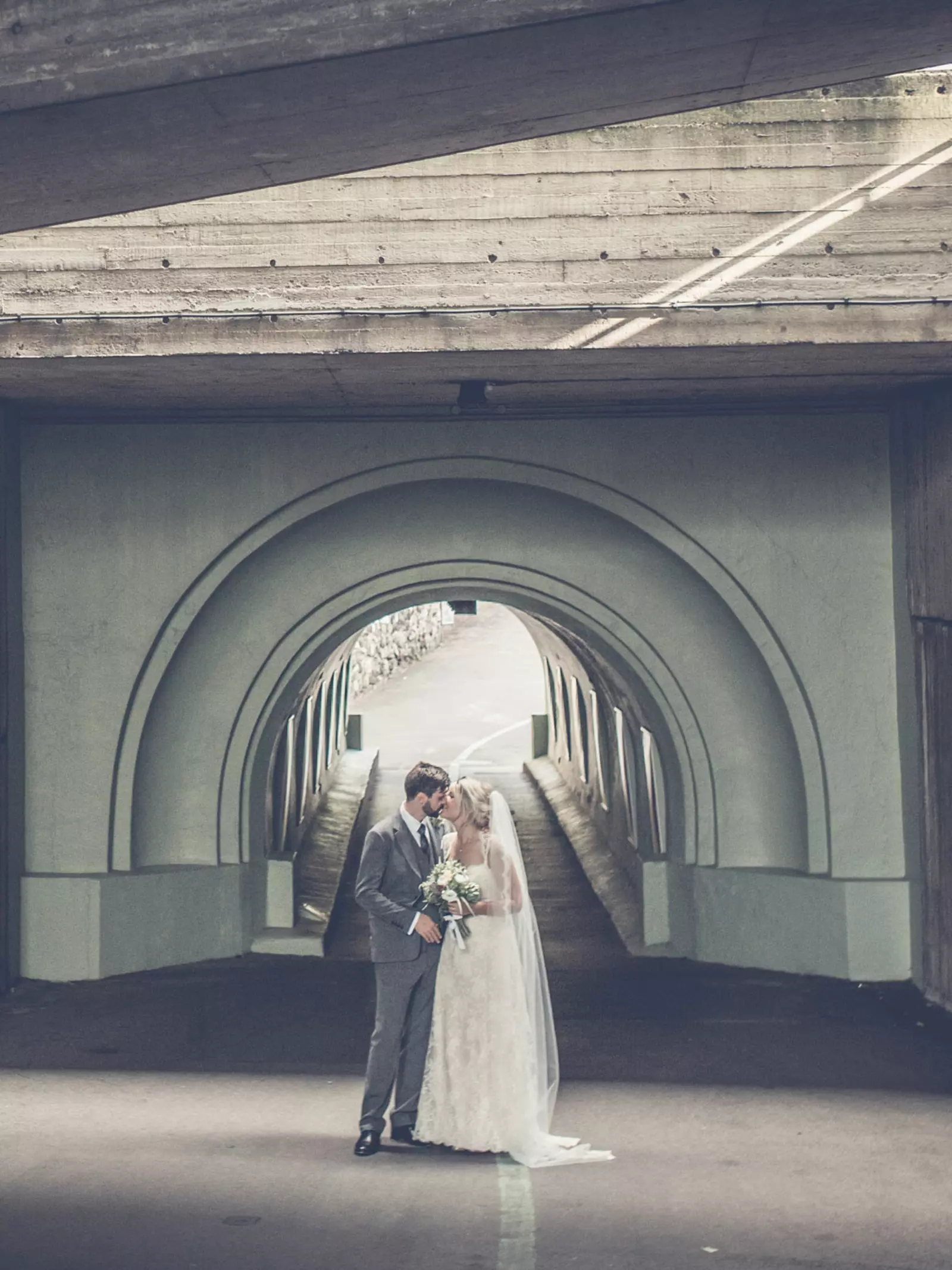 Wedding couple kissing in front of a tunnel at London Zoo 