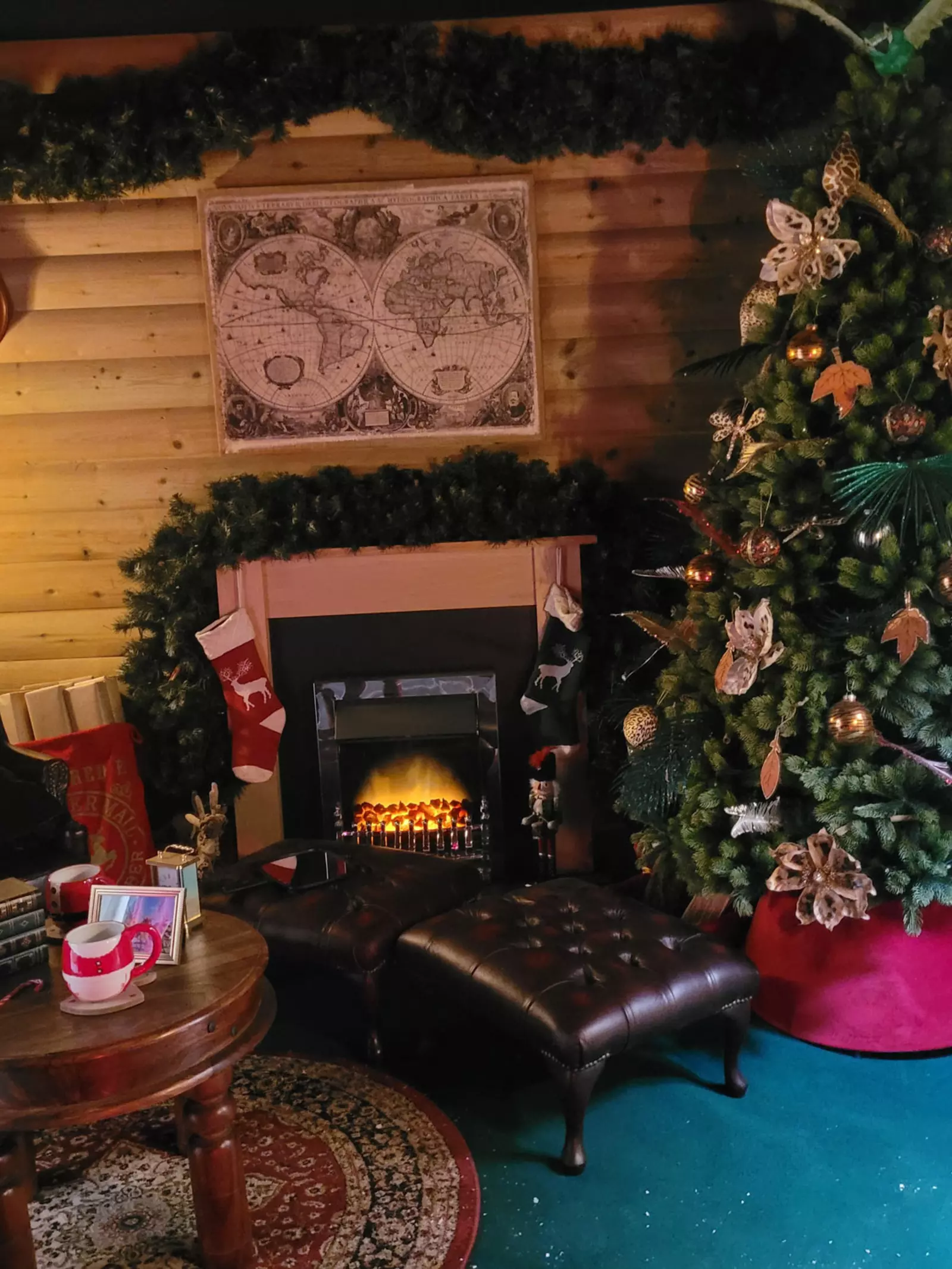 Christmas grotto decorated with a Christmas tree and stockings hanging on a fireplace