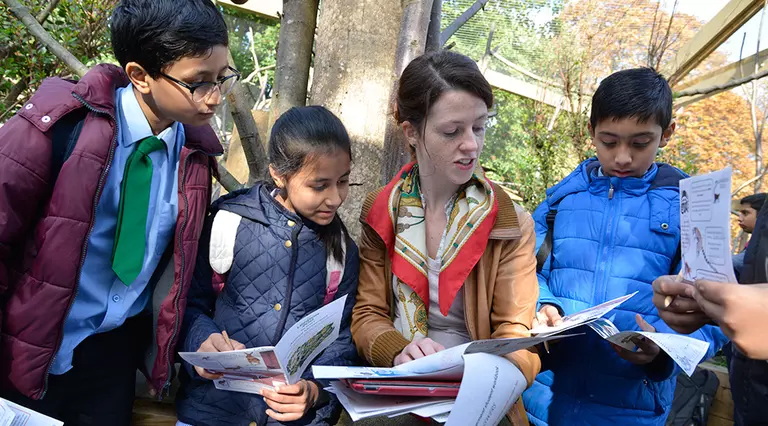 Teacher with students at London Zoo in lemur enclosure 