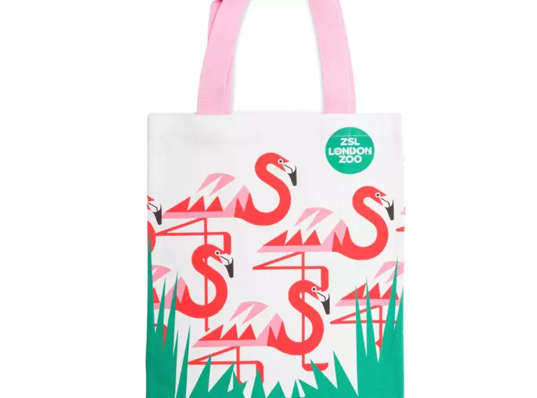 A tote bag with four flamingos on it