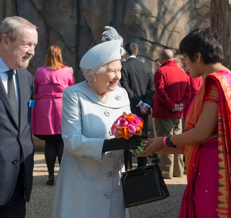 A ZSL conservationist presents HM The Queen with a bouquet of flowers